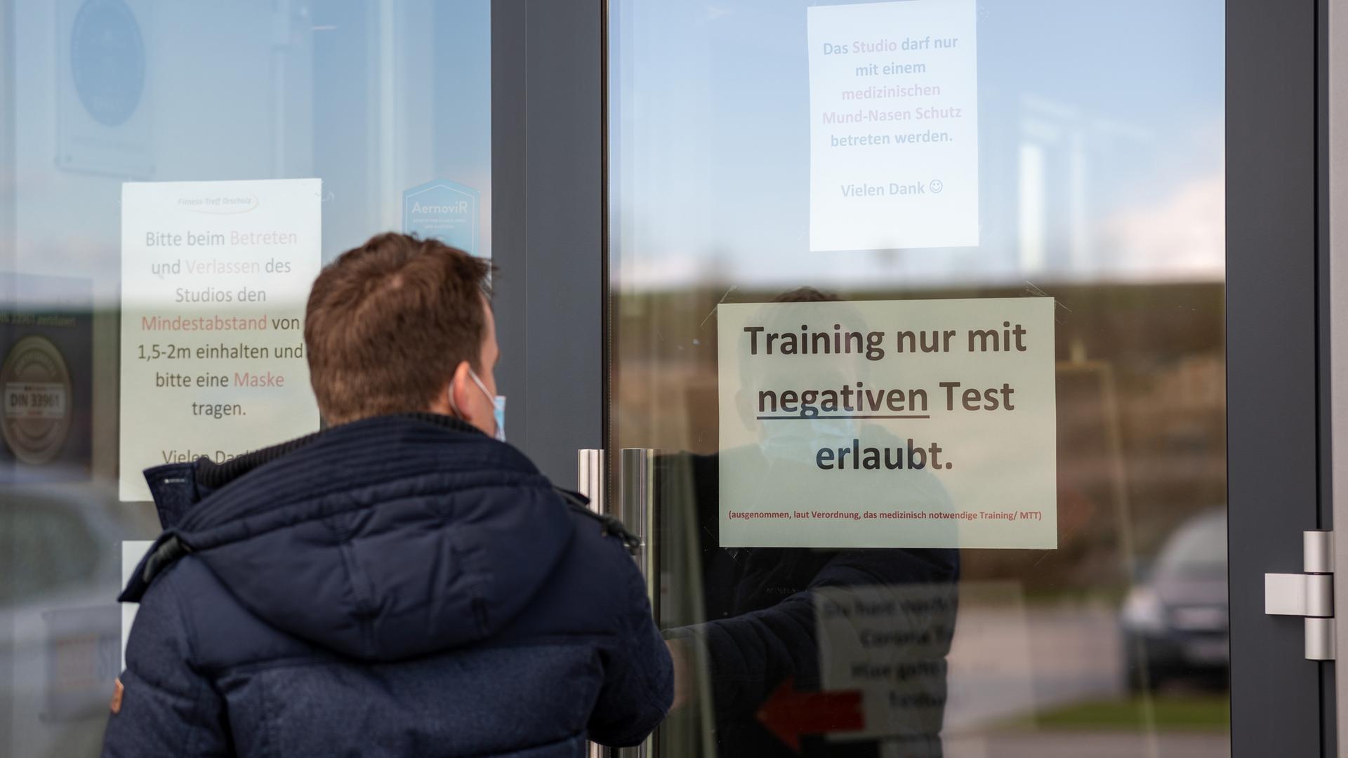Mann stehrt vor Eingang zu Fitnessstudio