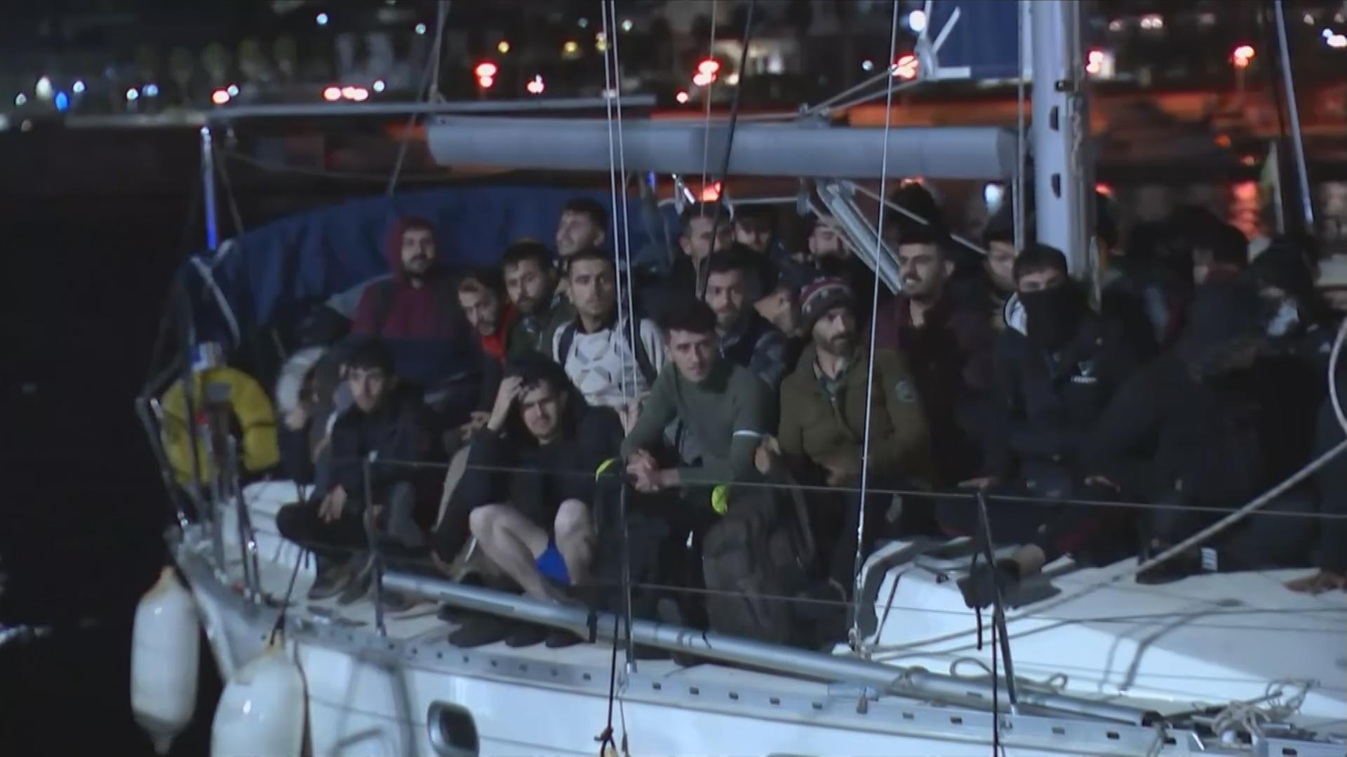 Flüchtlinge bei Nacht an Deck eines Segelbottes, das in einem italienischen Hafen liegt am 9.11.2021