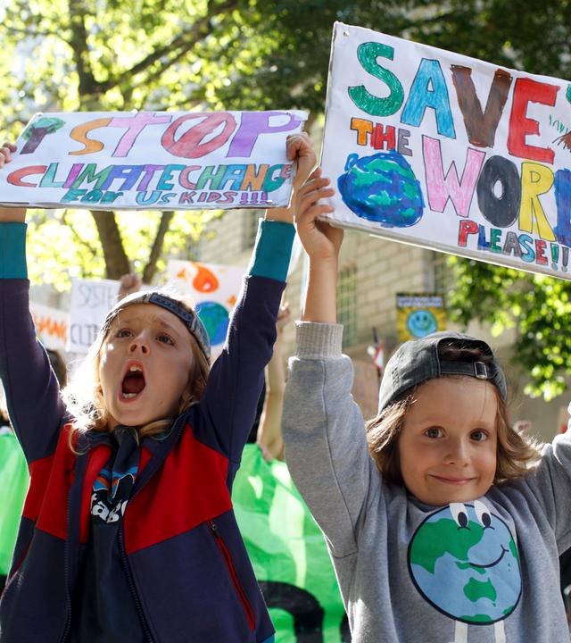 Prostestierende Kinder halten Schilder hoch
