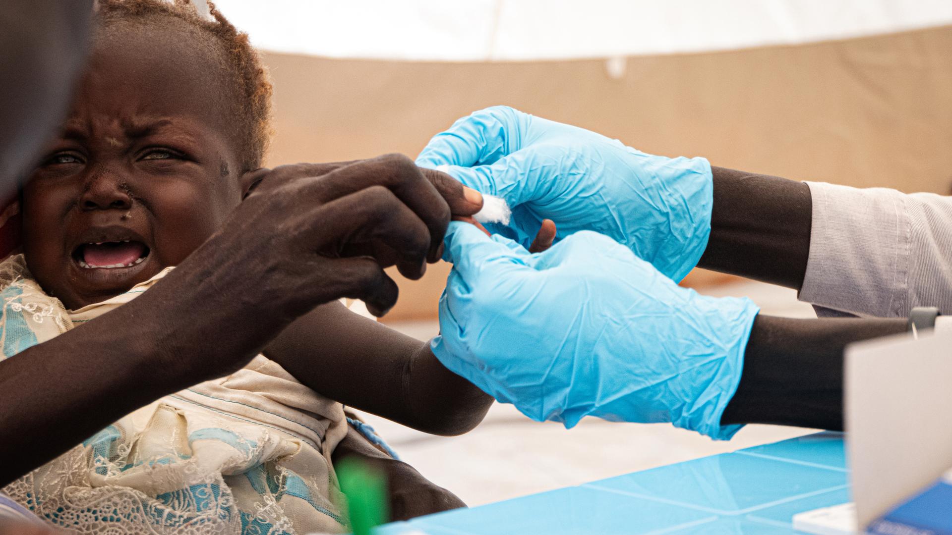 Kind wird gegegn Malaria geimpft