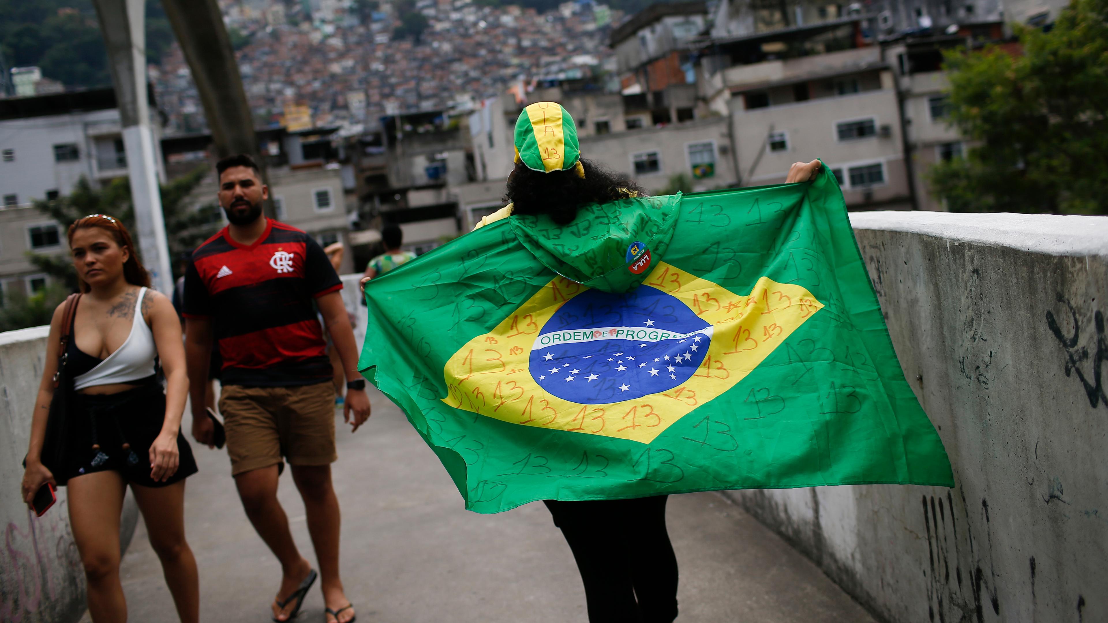 Eine Frau läuft mit einer Brasilienflagge läuft auf einer Brücke, Rio de Janeiro