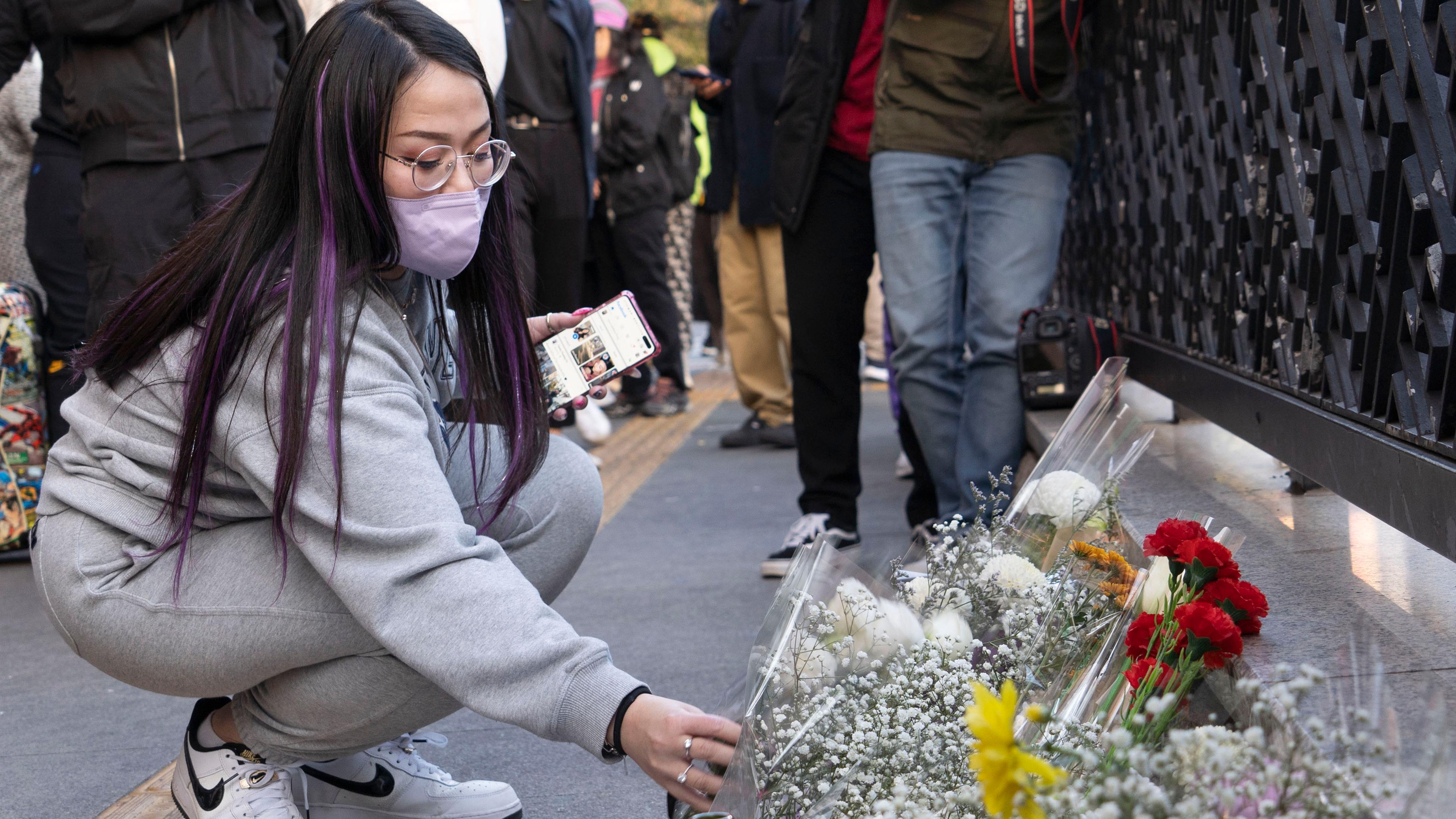 Eine Frau legt Blumen zur Trauen nieder, Seoul 30.10.2022