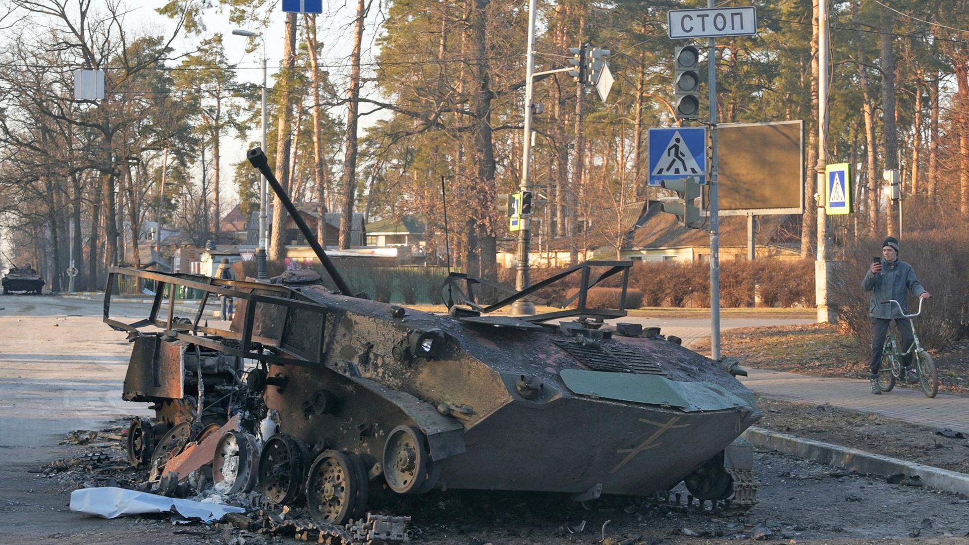 Bucha, 28.02.2022: Ein zerstörter Panzer liegt auf einer Straße.