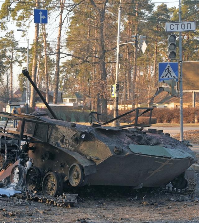 Bucha, 28.02.2022: Ein zerstörter Panzer liegt auf einer Straße.