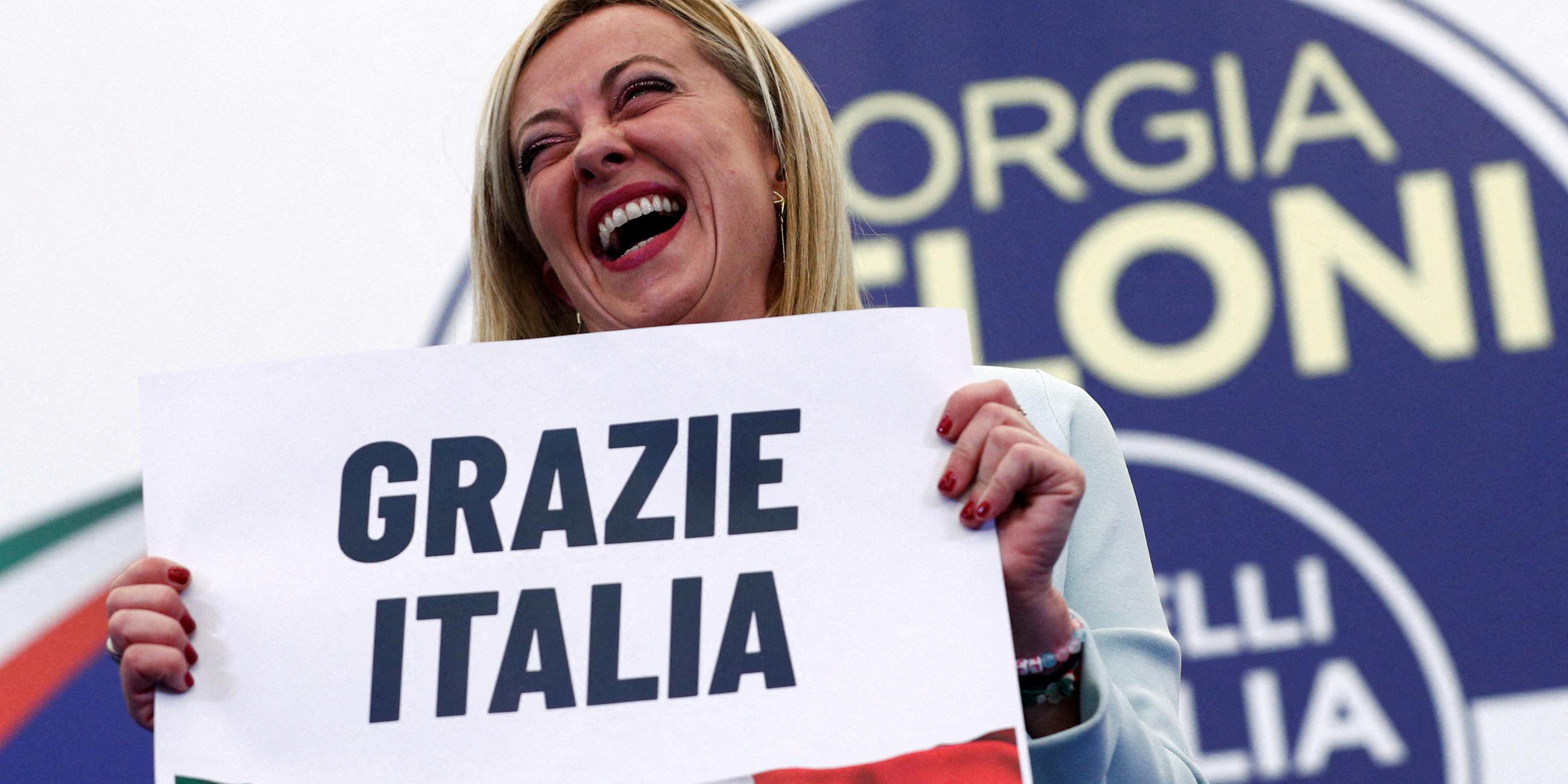 Siegerin Giorgia Meloni hält ein Schild in den Händen mit der Aufschrift "Grazie Italia". Rom, 26.09.2022