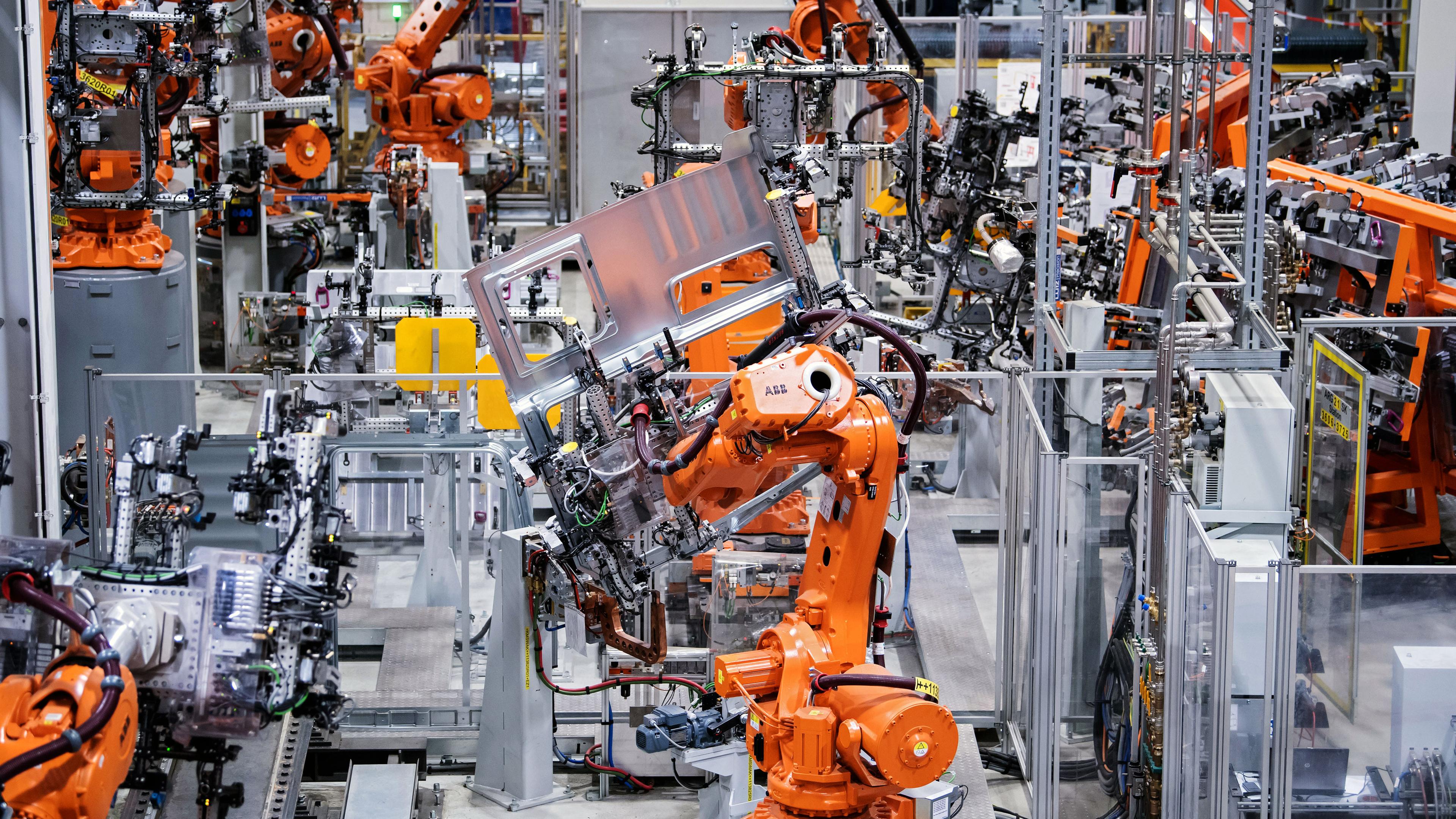 Orange lackierte Roboter arbeiten bei MAN an Fertigung von LKW