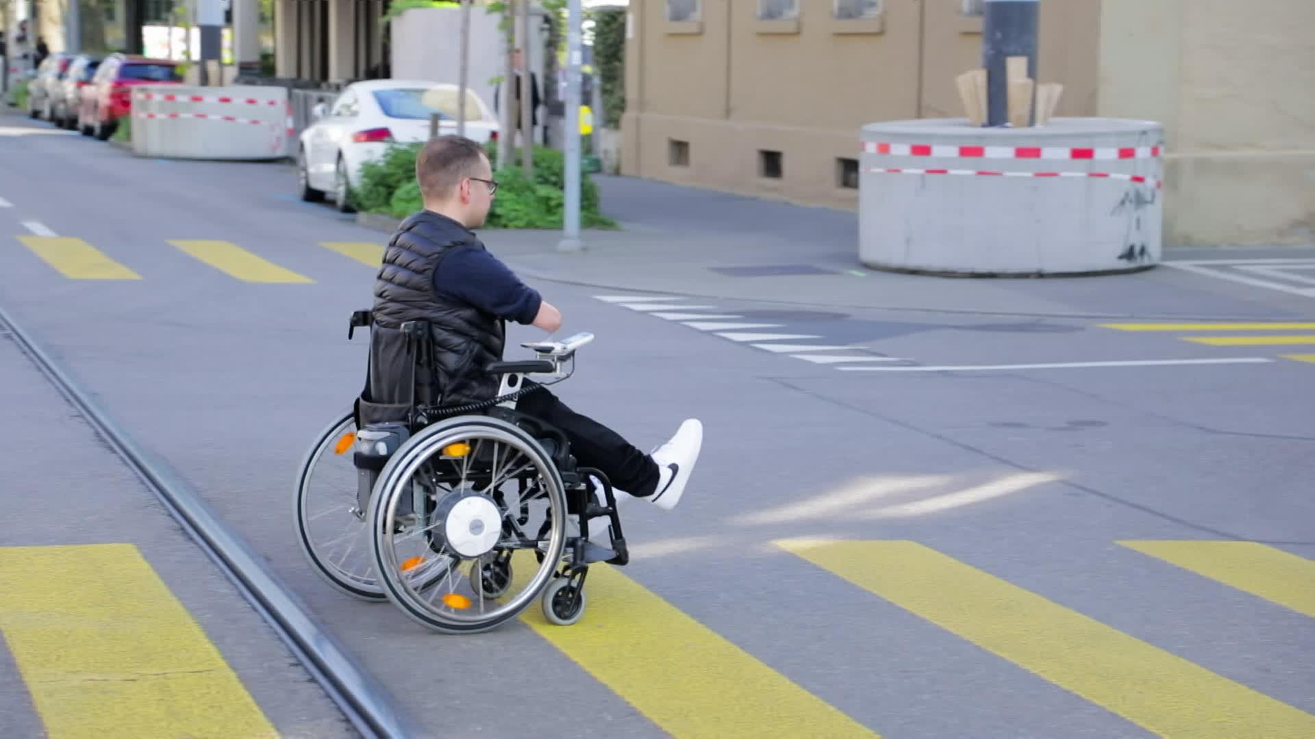 Mann in einem Rollstuhl überquert die Straße