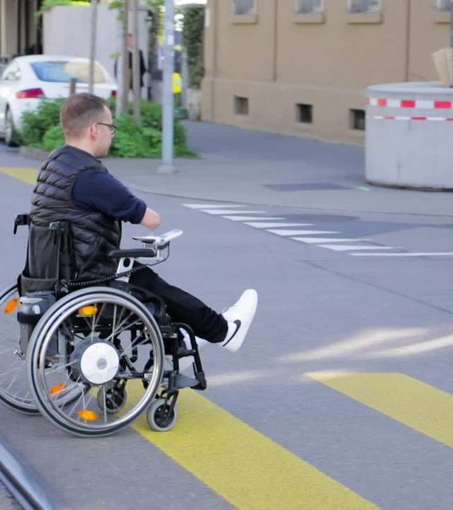 Mann in einem Rollstuhl überquert die Straße