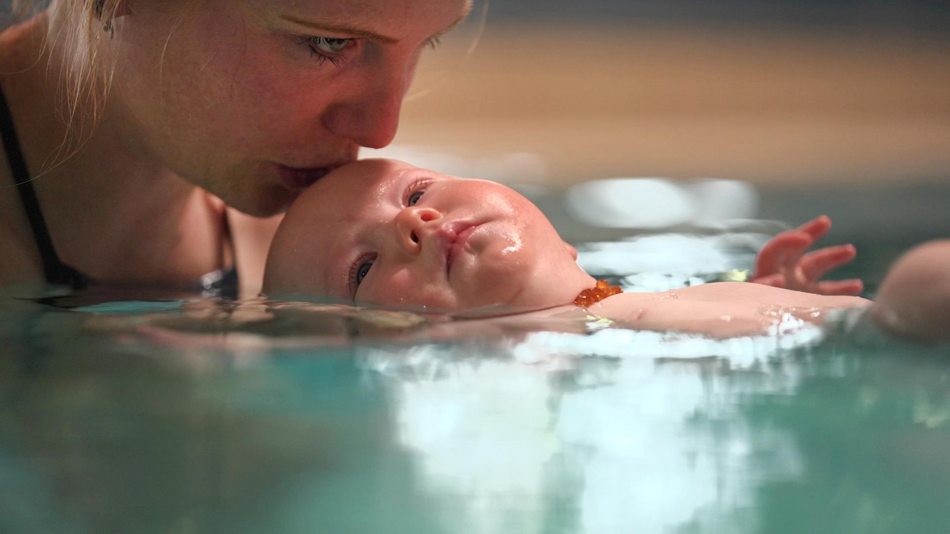 Frau mit Baby im Wasser