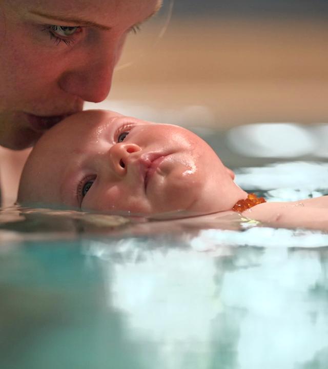 Frau mit Baby im Wasser