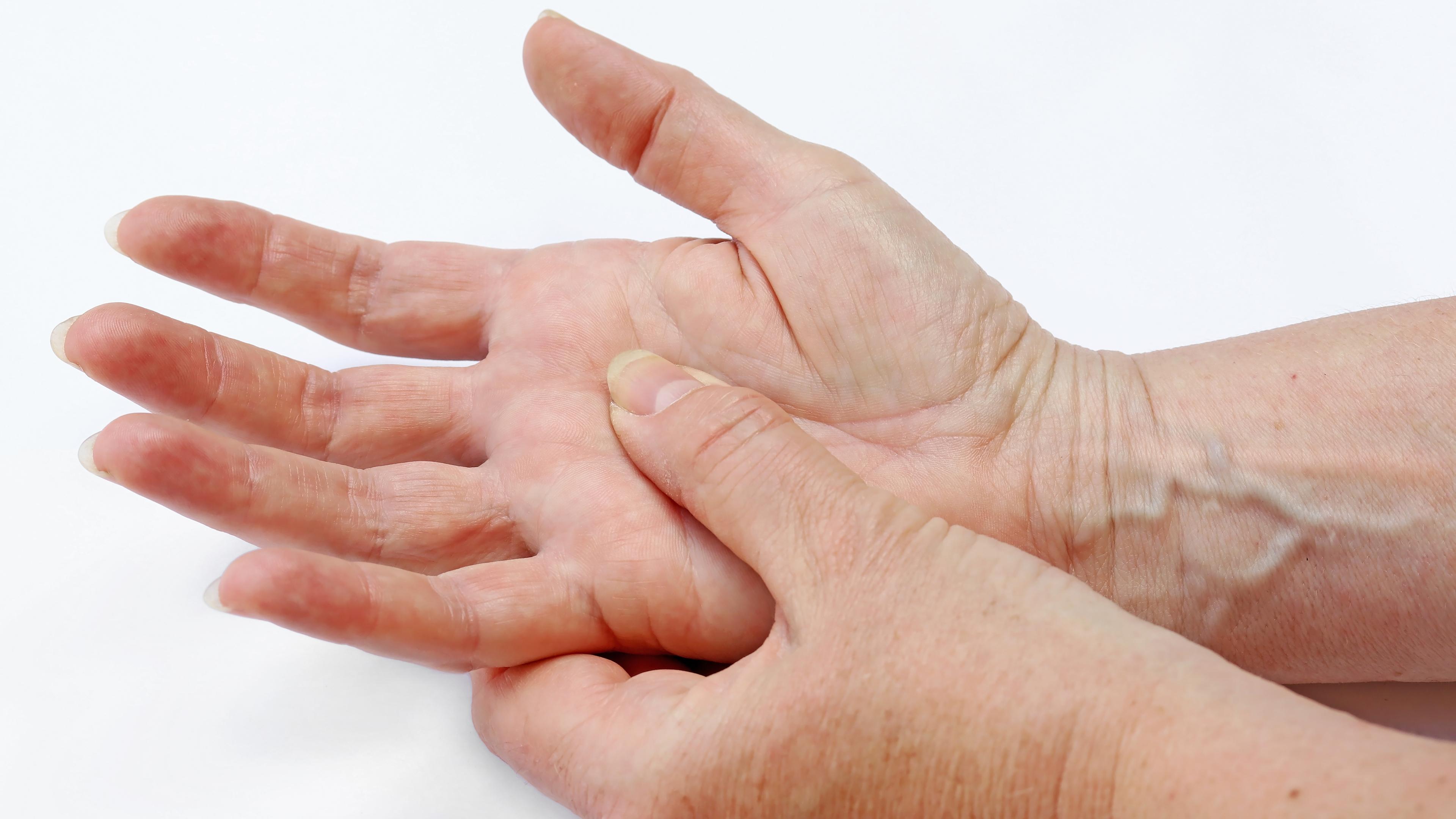  Nahaufnahme von zwei Händen, wobei die linke Hand die rechte Handfläche umfasst.