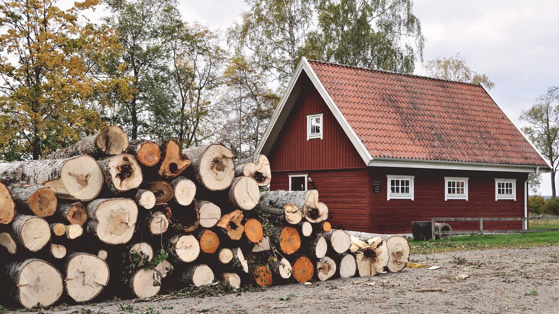 Haus in Schweden, im Vordergrund ein Holzstapel