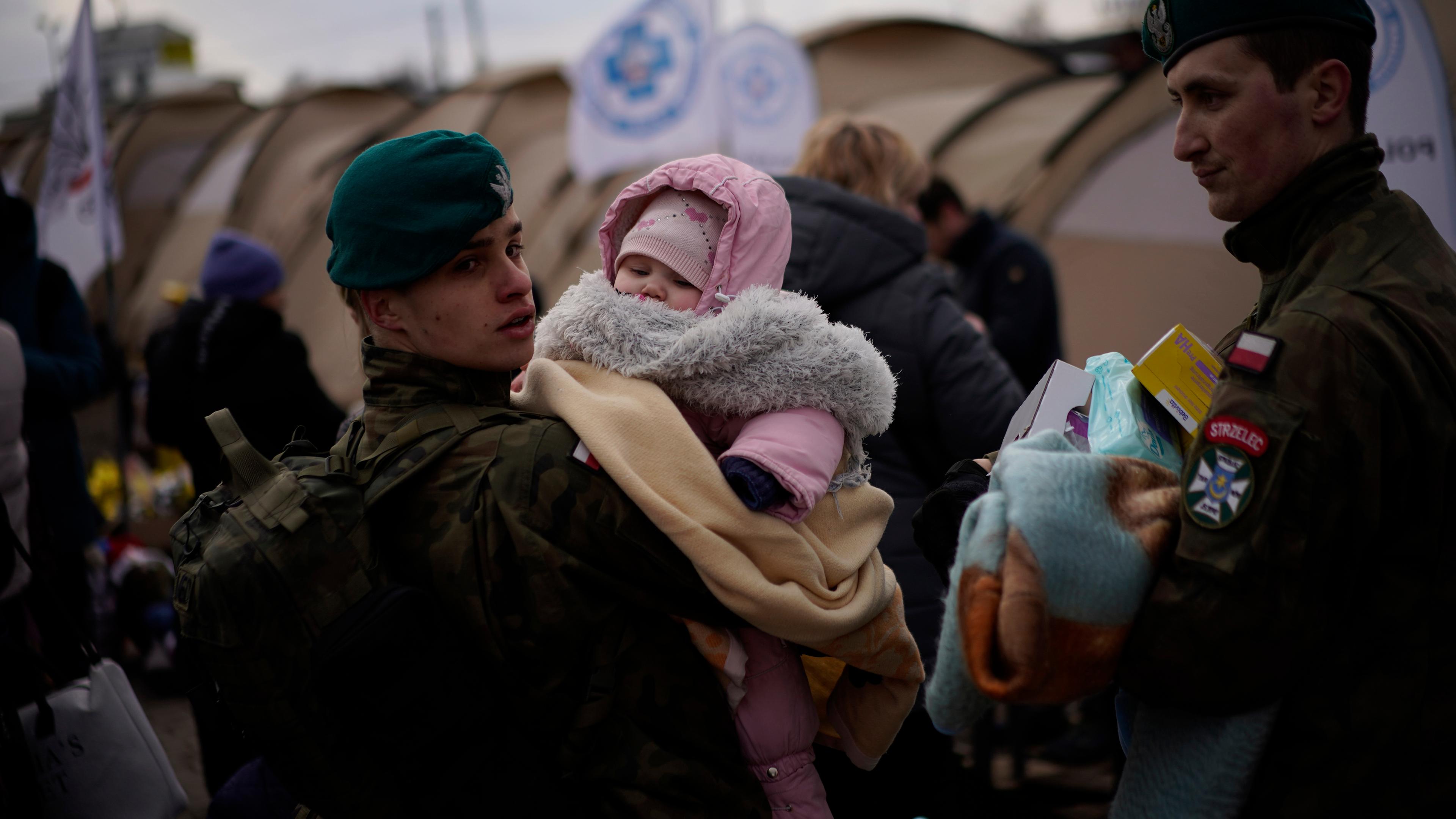 Polnische soldaten und ukrainische Flüchtlinge