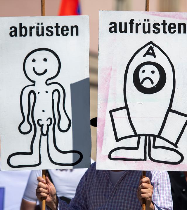 Demo: Schilder mit Aufschrift "abrüsten" "aufrüsten"