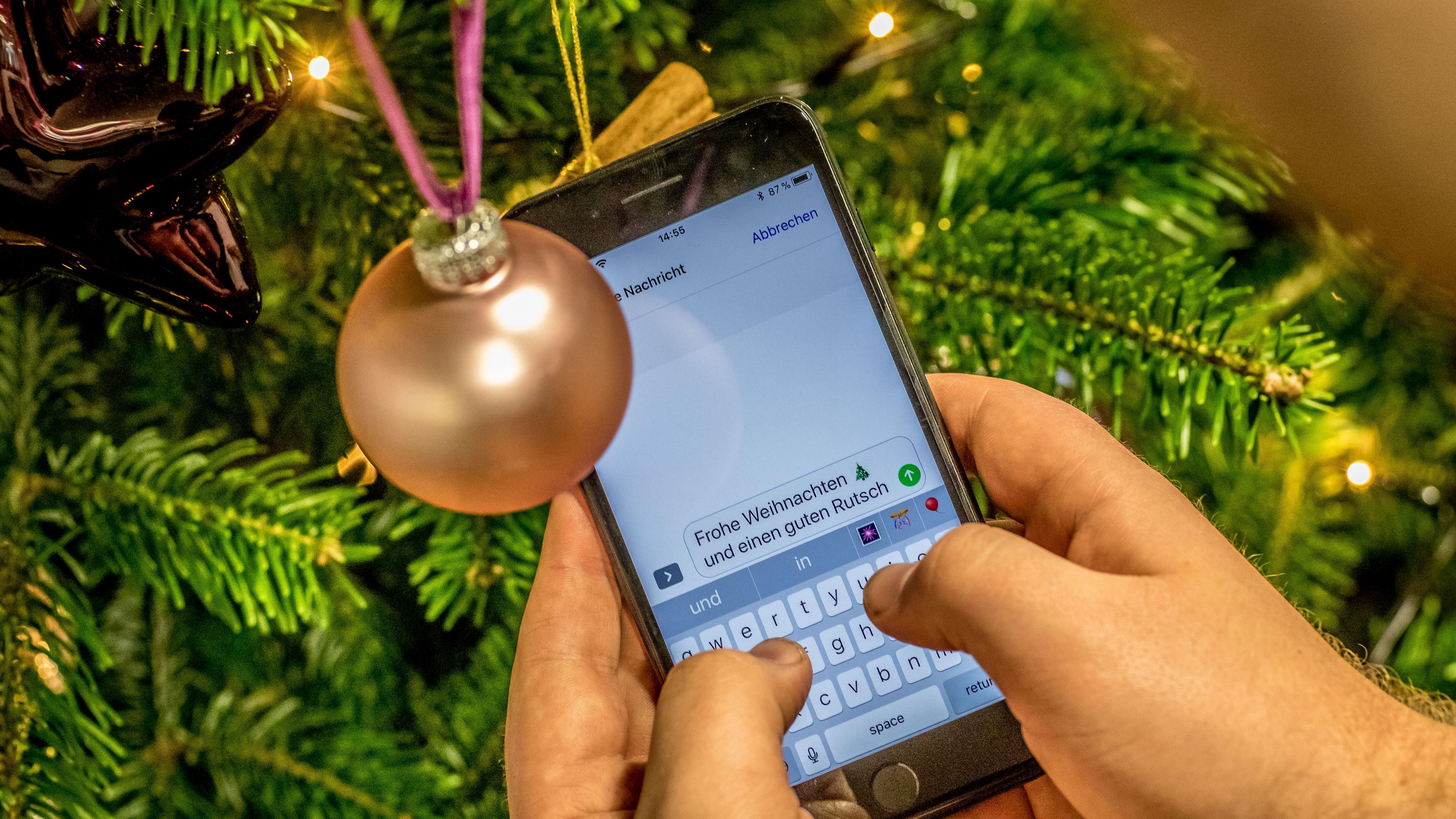 Handy mit SMS vor einer Weihnachtskugel