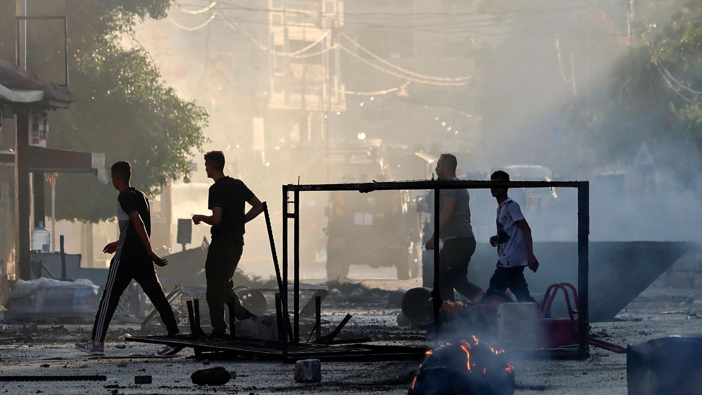 Dschenin, 03.07.2023: Palästinenser laufen durch zerstörte Straßen in Dschenin.