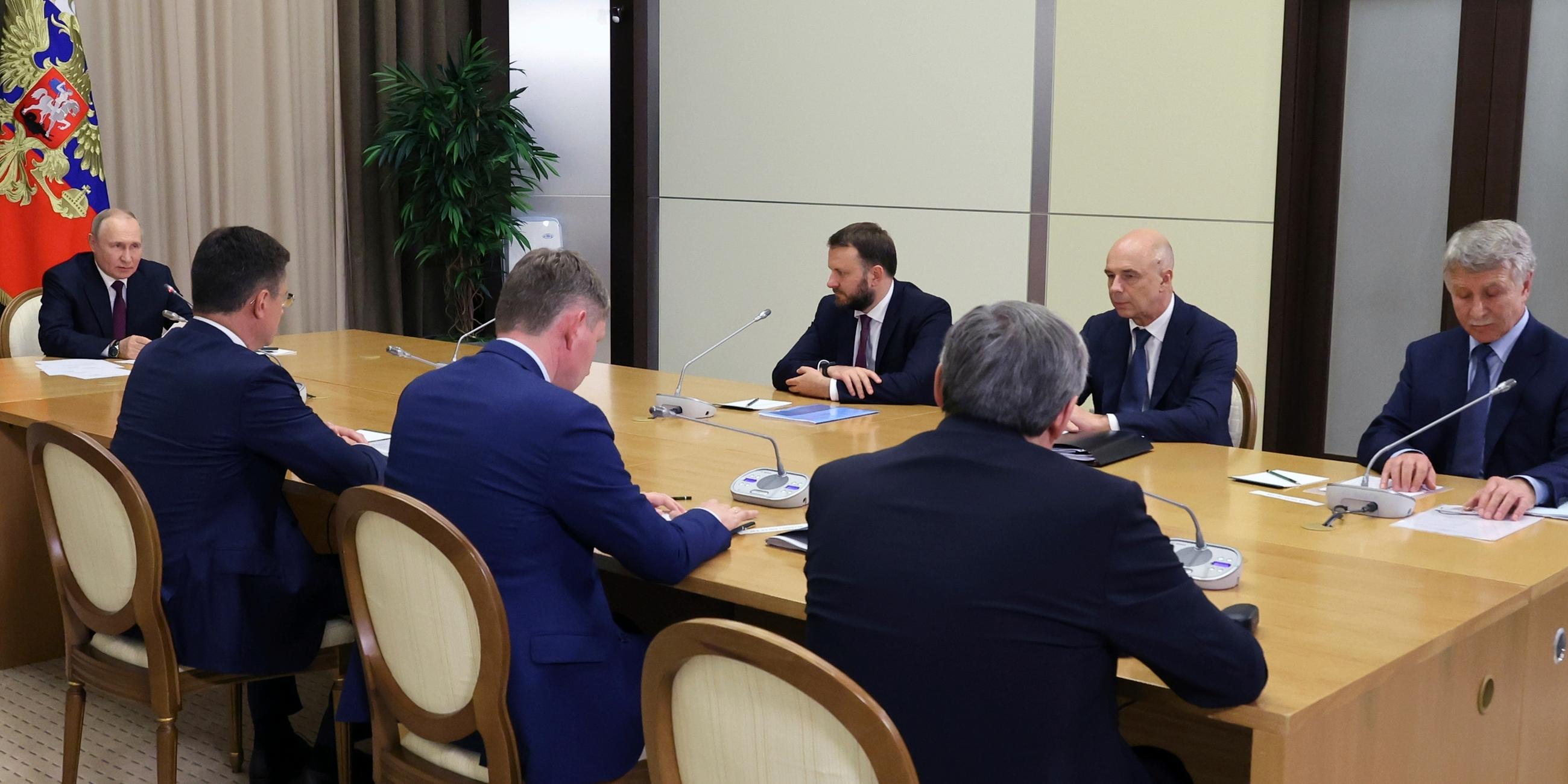 Putin und seine Delegation am Tisch.