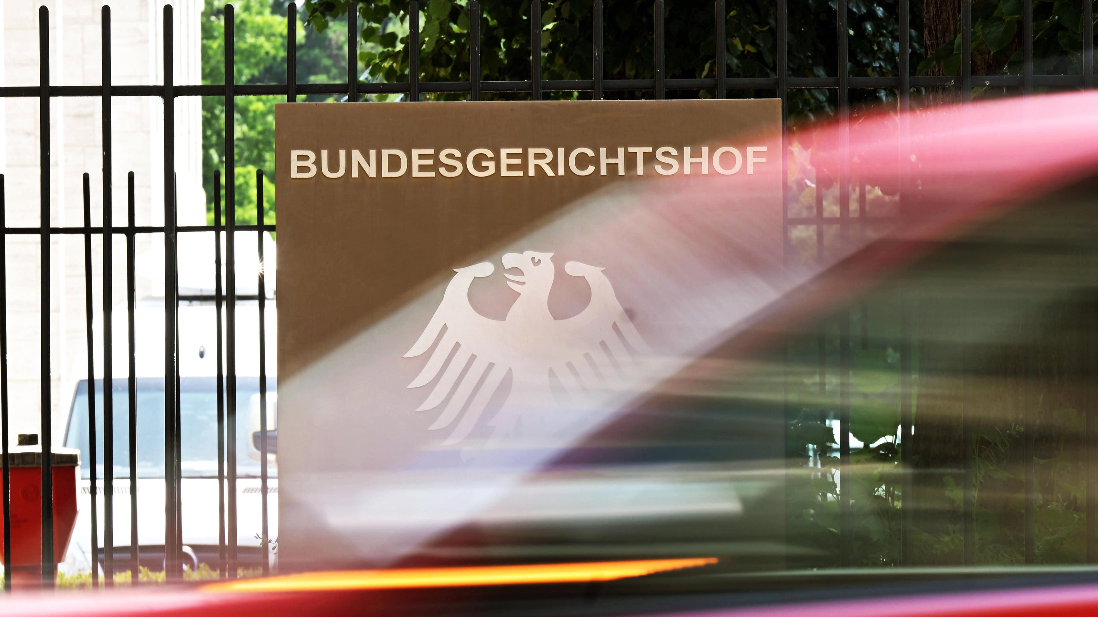 Schild des Bundesgerichtshofs, im Vordergrund fährt ein Autor vorbei am 26.06.2023, Karlsruhe, Baden-Württemberg
