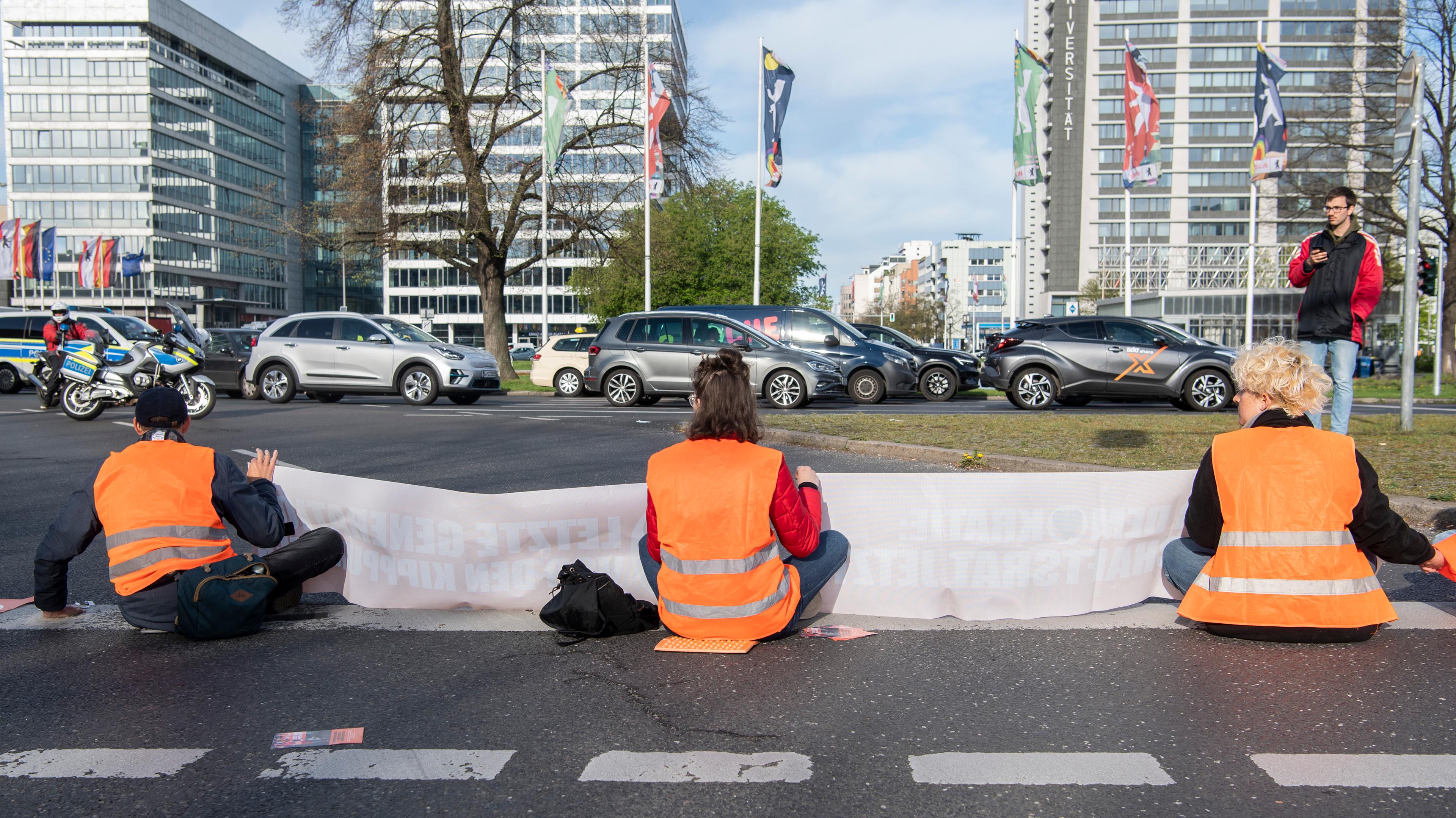 24.04.2023, Berlin: Aktivisten der Gruppierung «Letzte Generation» blockieren eine Ausfahrt am Ernst-Reuter-Platz.