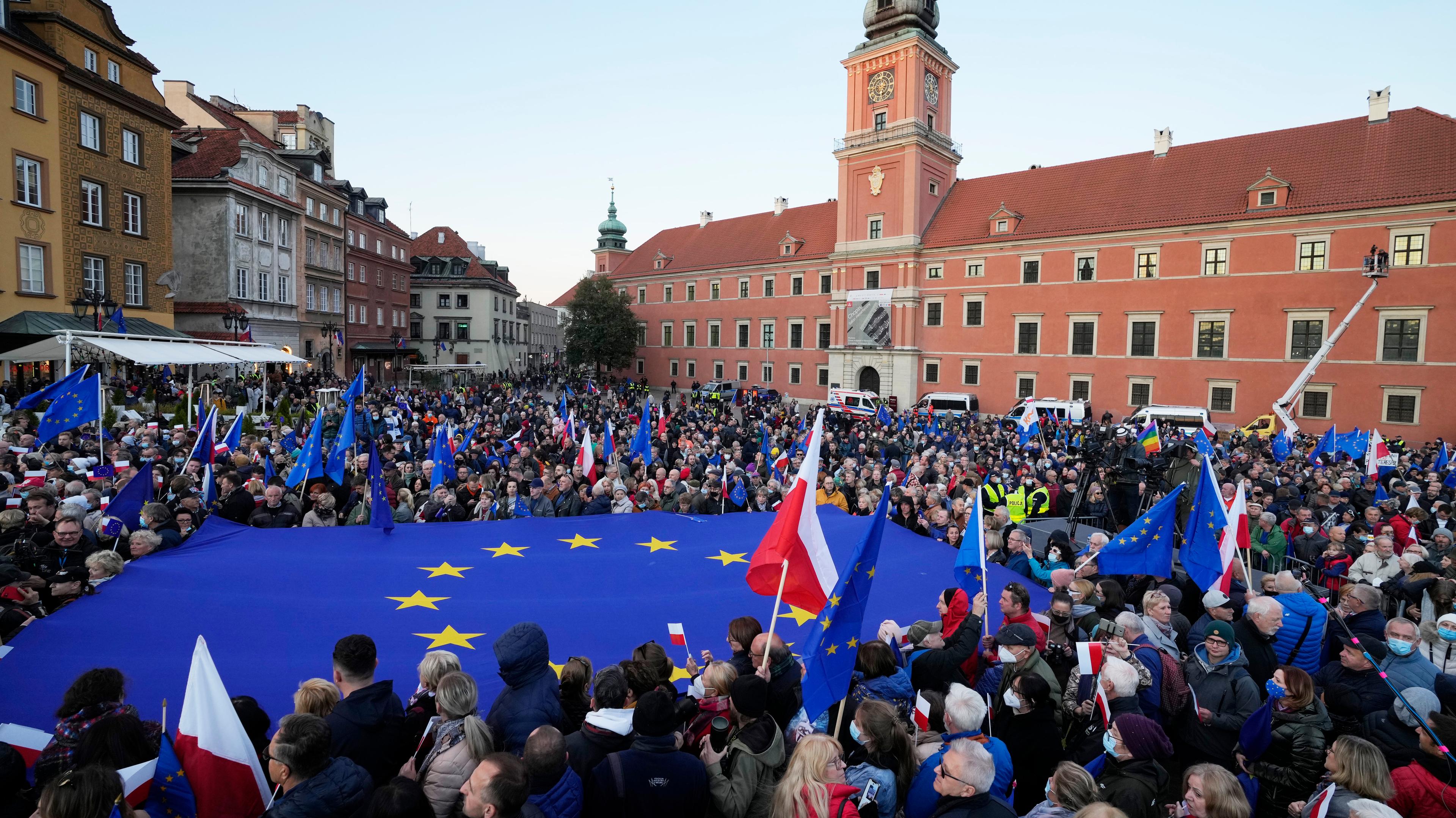 10.10.2021: Menschen schwenken EU- und polnische Flaggen in Warschau.