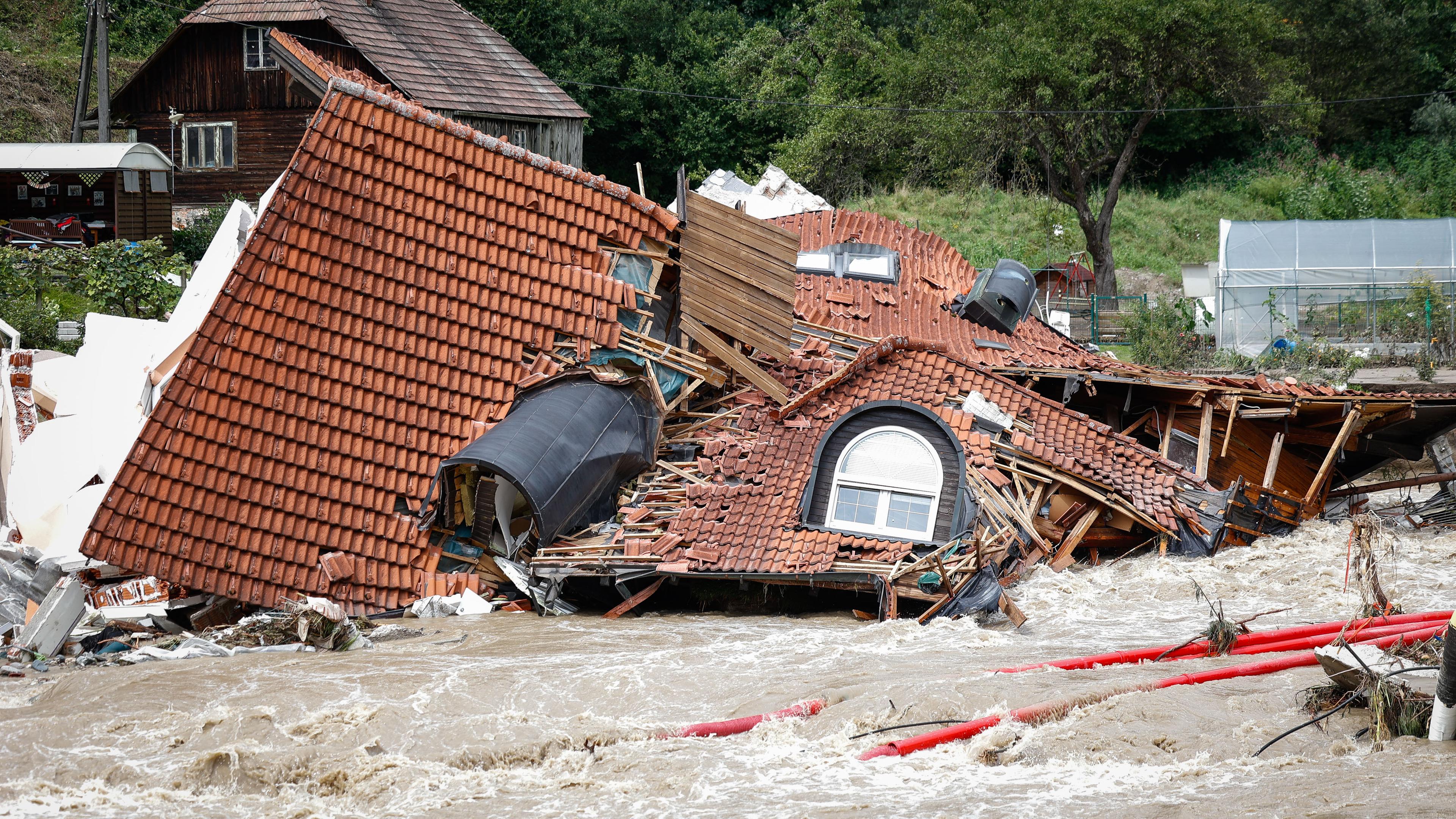 Ein zusammengestürztes Haus liegt in den Fluten