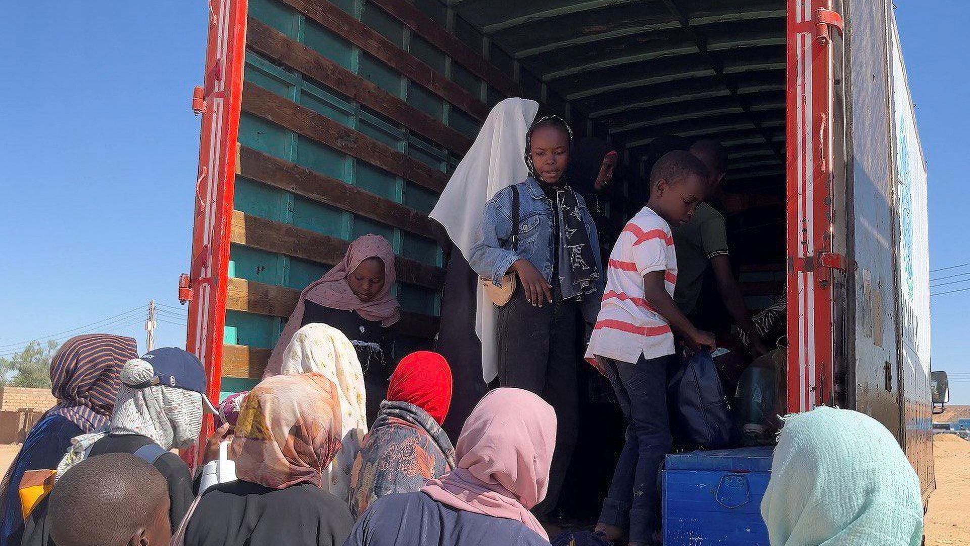 Wadi Halfa, 02.05.2023: Menschen aus dem Sudan stehen vor und in einem Lastwagen, bereit zur Flucht aus ihrem Heimatland.