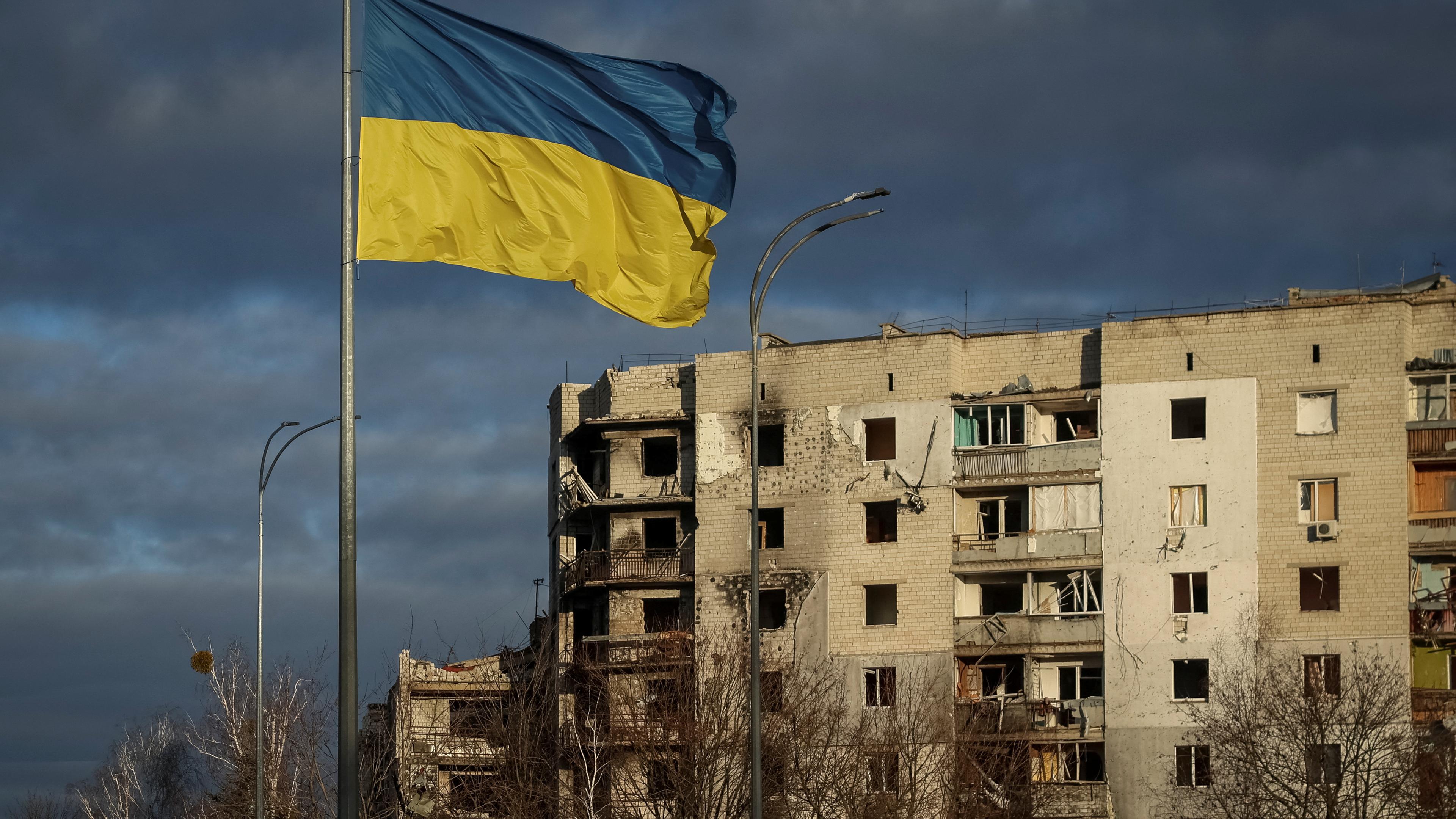 Ukrainische Flagge weht vor zerstörtem Haus, Borodianka 15.02.2023