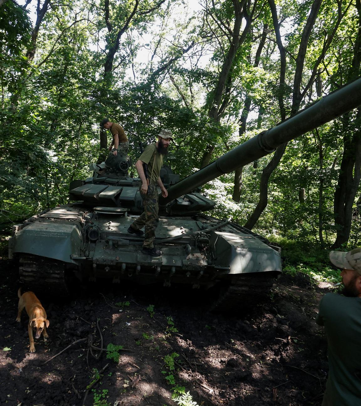 Ein erbeuteter Panzer der Russen, an dem ukrainische Soladten stehen.