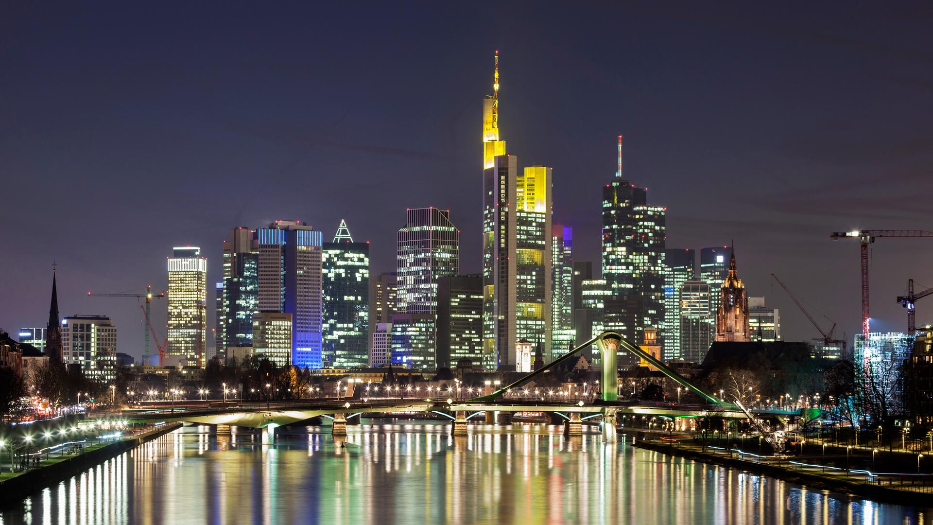Frankfurt am Main: Hochhäuser spiegeln sich im Abendlicht auf einem Fluss.