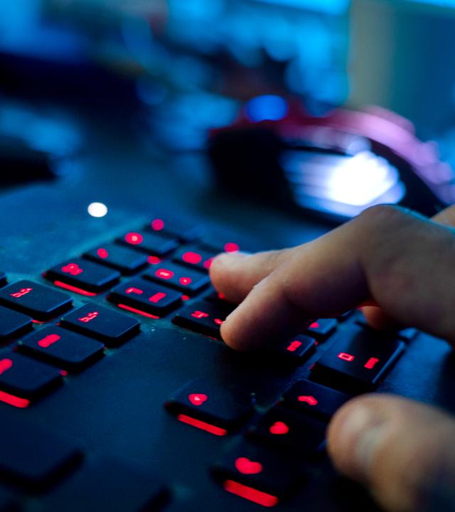 Hand tippt auf Laptop-Tastatur