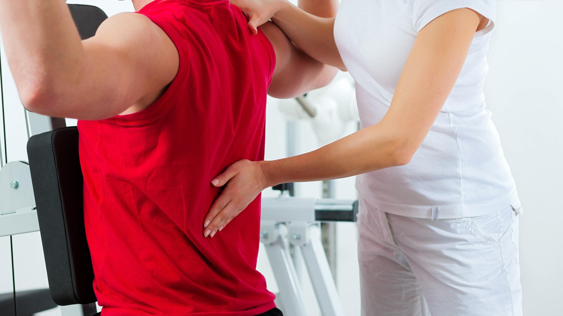 Rückenschmerzpatient mit Physio-Therapeutin 
