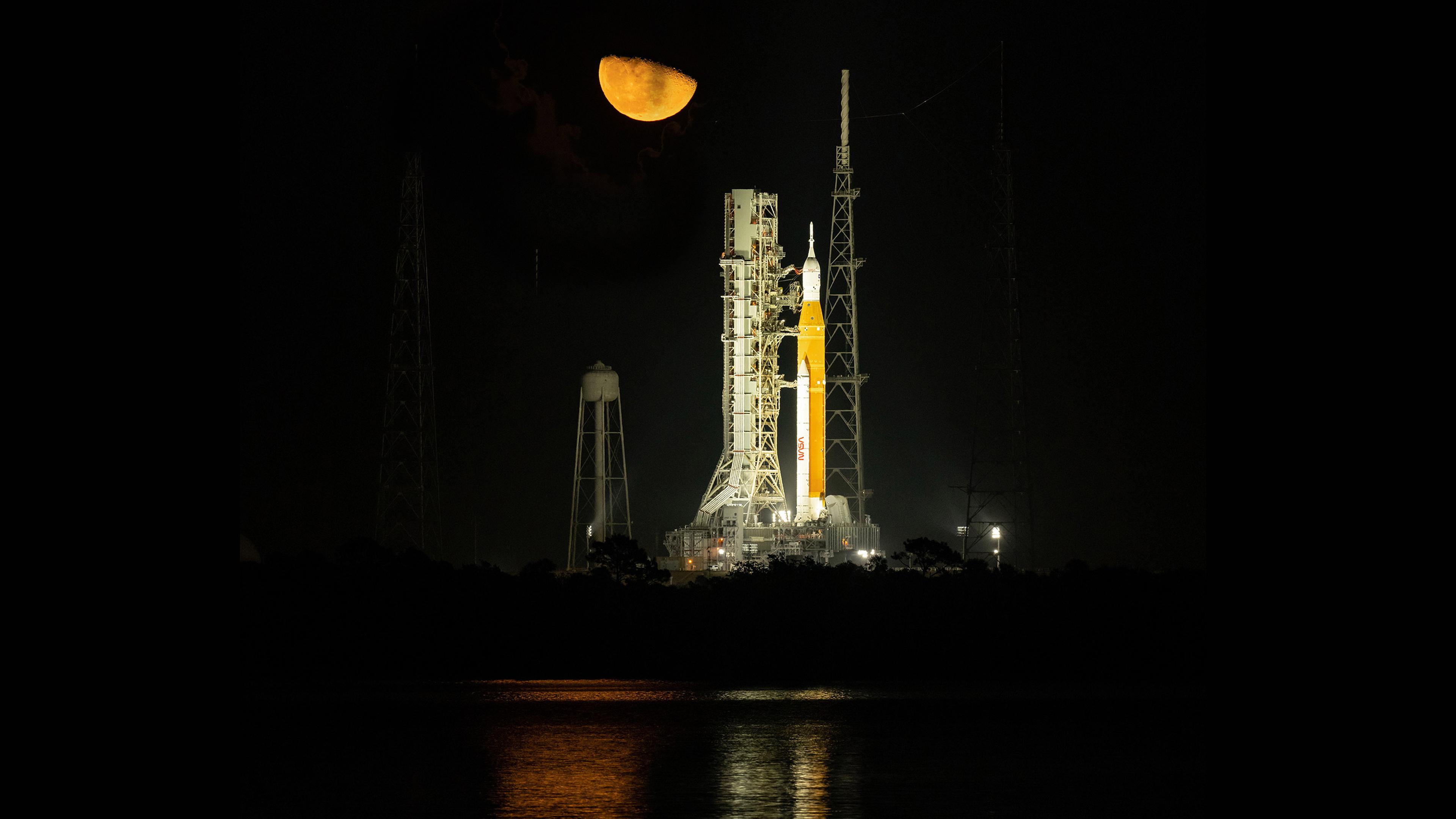 Nachtaufnahme der hell angestrahlten neuen Mondrakete SLS, die vor dem Start auf der Startrampe steht