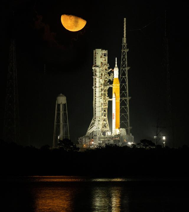 Nachtaufnahme der hell angestrahlten neuen Mondrakete SLS, die vor dem Start auf der Startrampe steht