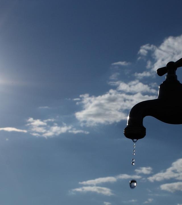 Wasserhahn vor blauem Sommerhimmel