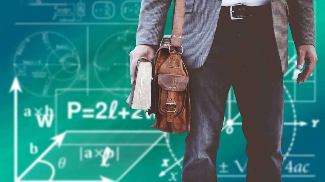 Man with leather bag in front of blackboard