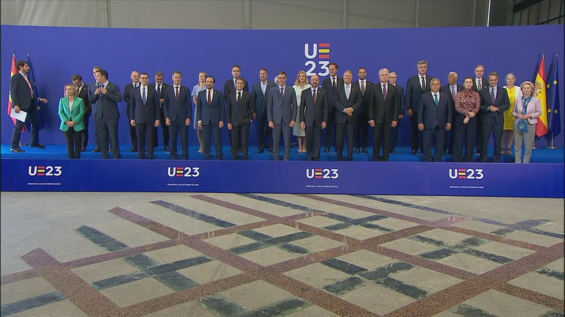 Staats-und Regierungschefs stehen für ein Gruppenbild vor einer blauen Wand