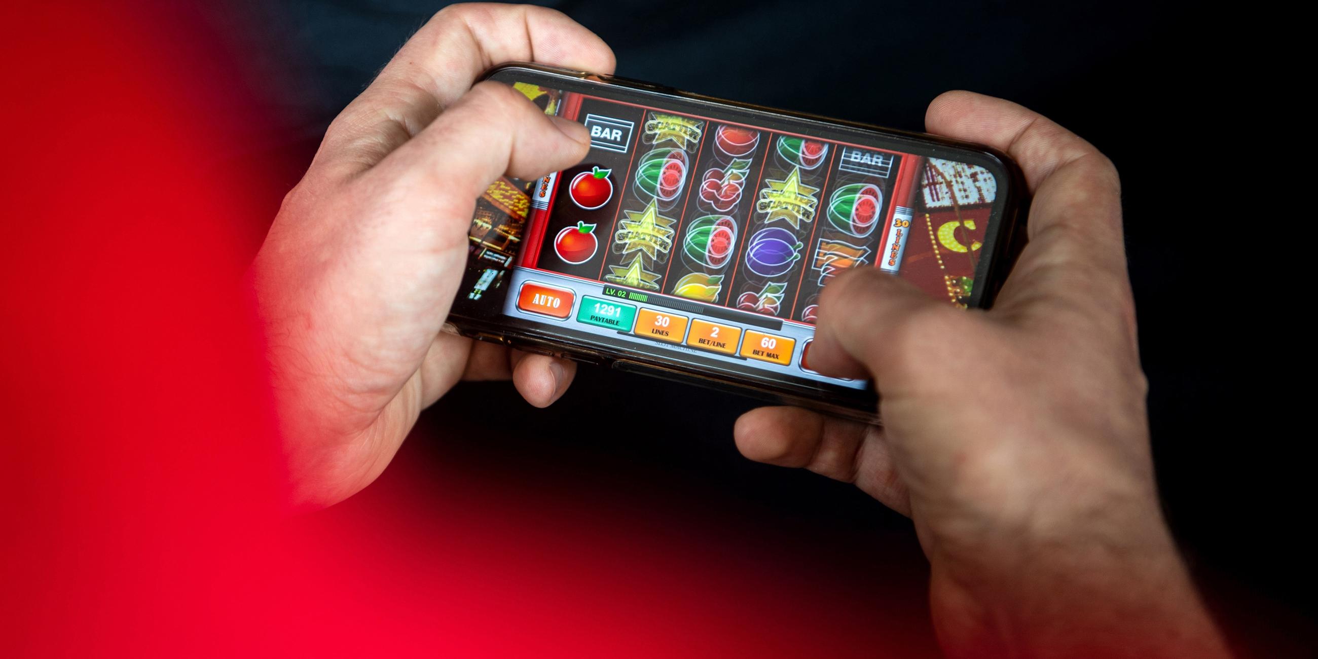 Zwei Hände halten ein Smartphone, darauf wird ein Online-Spiel gespielt.