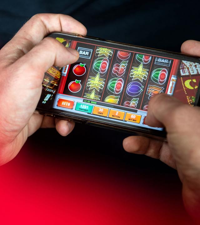 Zwei Hände halten ein Smartphone, darauf wird ein Online-Spiel gespielt.