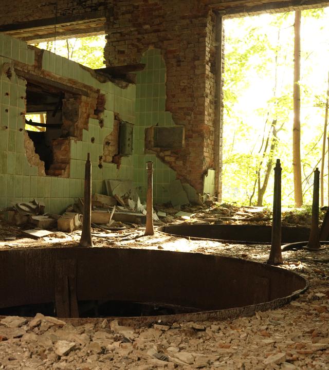 Das Innere einer völlig heruntergekommenen Brauerei-Ruine im brandenburgischen Wiesenburg. Im Vordergund klafft ein großes, rundes Loch im Boden, im Hintergrund blickt man duch einen großen Duchbruch ins Freie.