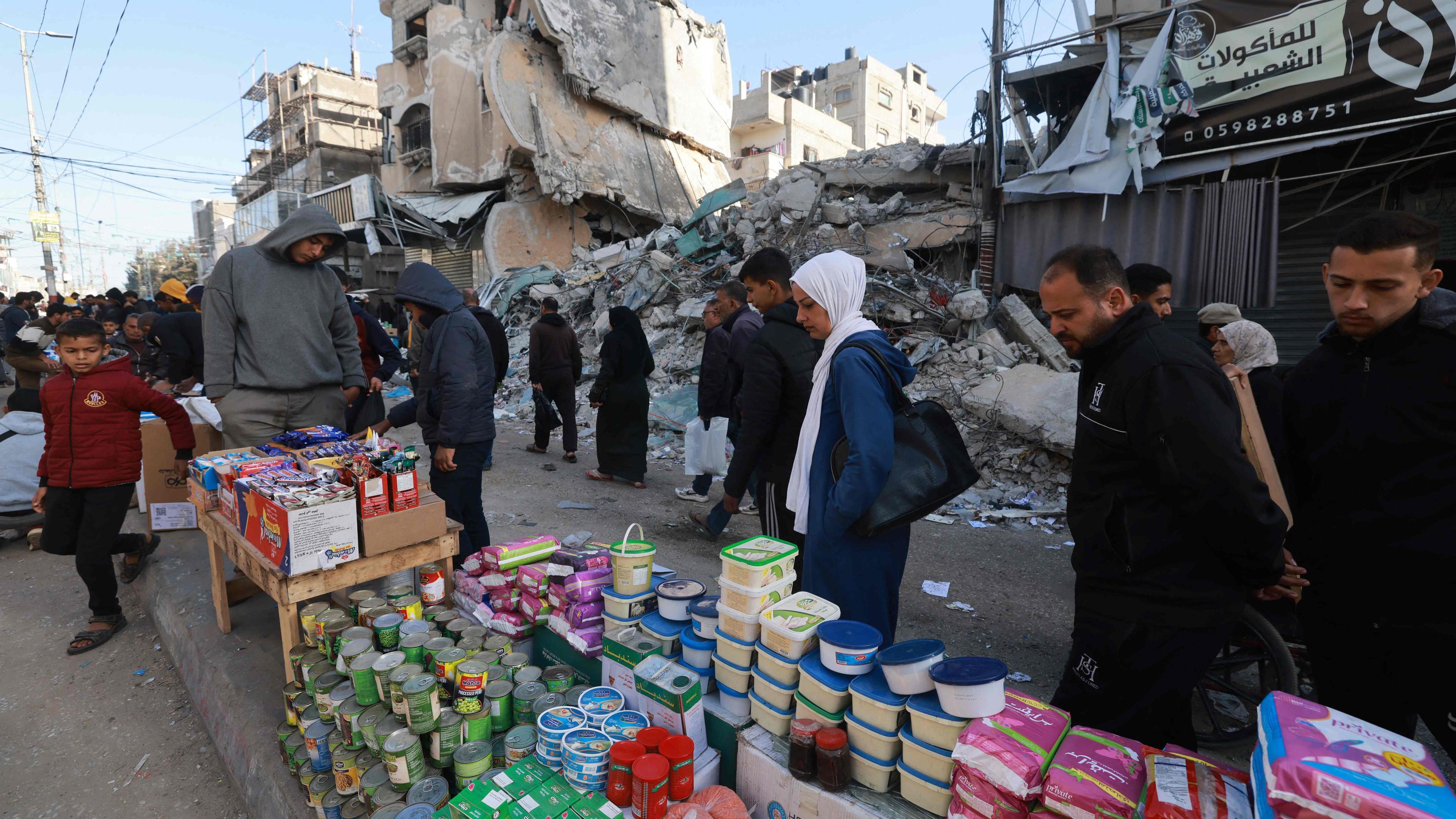 Palästinenser gehen am 10. März 2024 an Ständen vorbei, die in einer Straße in Rafah im südlichen Gazastreifen aufgebaut sind. Die Muslime bereiten sich inmitten der anhaltenden Kämpfe zwischen Israel und der militanten palästinensischen Gruppe Hamas auf den heiligen Fastenmonat Ramadan vor.