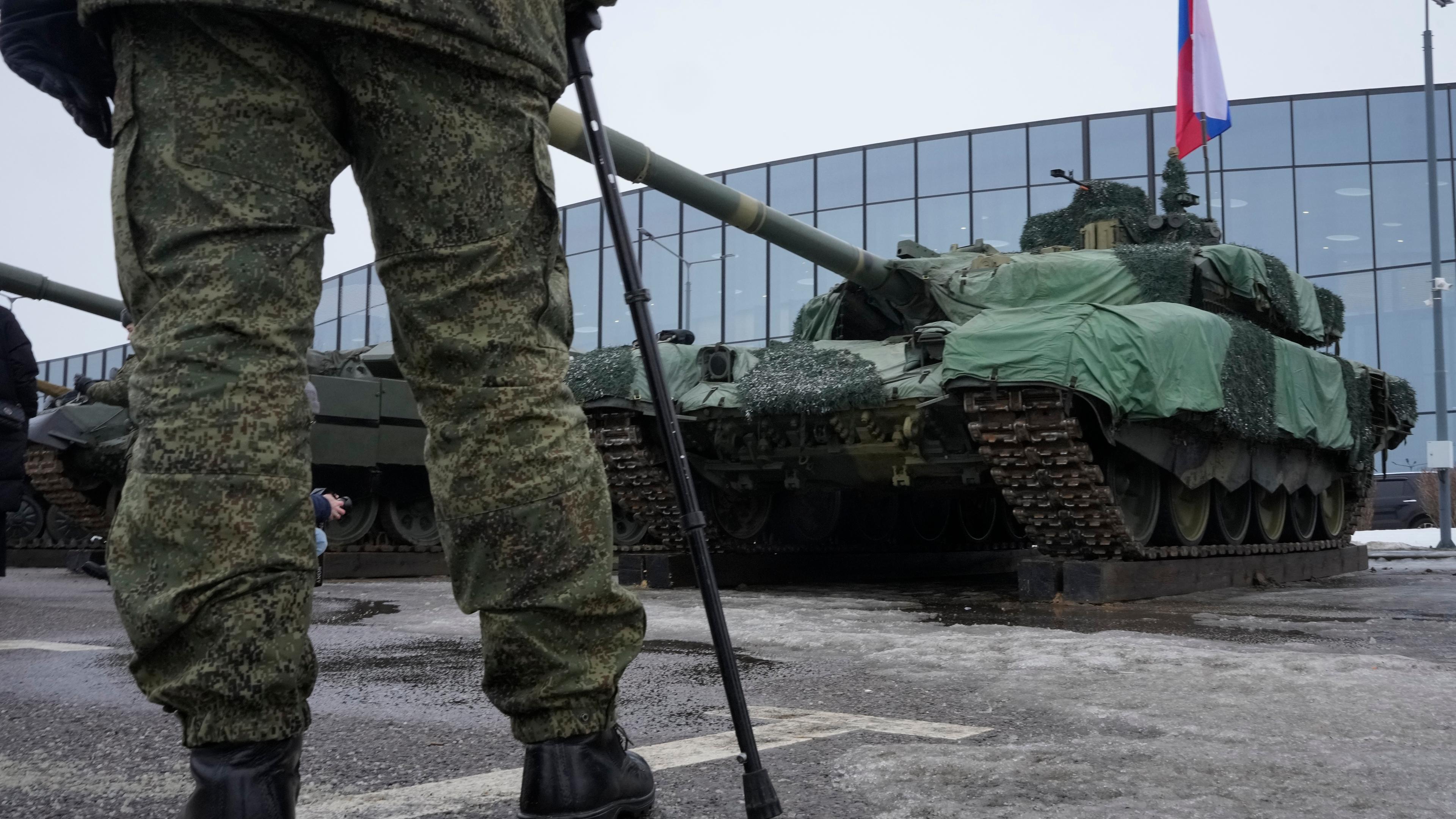 24.02.24, St. Petersburg: Ein russischer Soldat steht vor einm Panzer mit Russlandfahne.