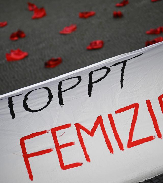 25.11.2024, Berlin: Ein Banner mit der Aufschrift «Stoppt Femizide» hängt vor roten Schuhen, die anlässlich des Internationalen Tags für die Beseitigung von Gewalt gegen Frauen vor dem Rathaus Tiergarten stehen. Die Aktion ist angelehnt an das Projekt «Zapatos Rojos» (dt. Rote Schuhe) der mexikanischen Künstlerin Chauvet, die damit gegen Gewalt an Frauen protestiert.
