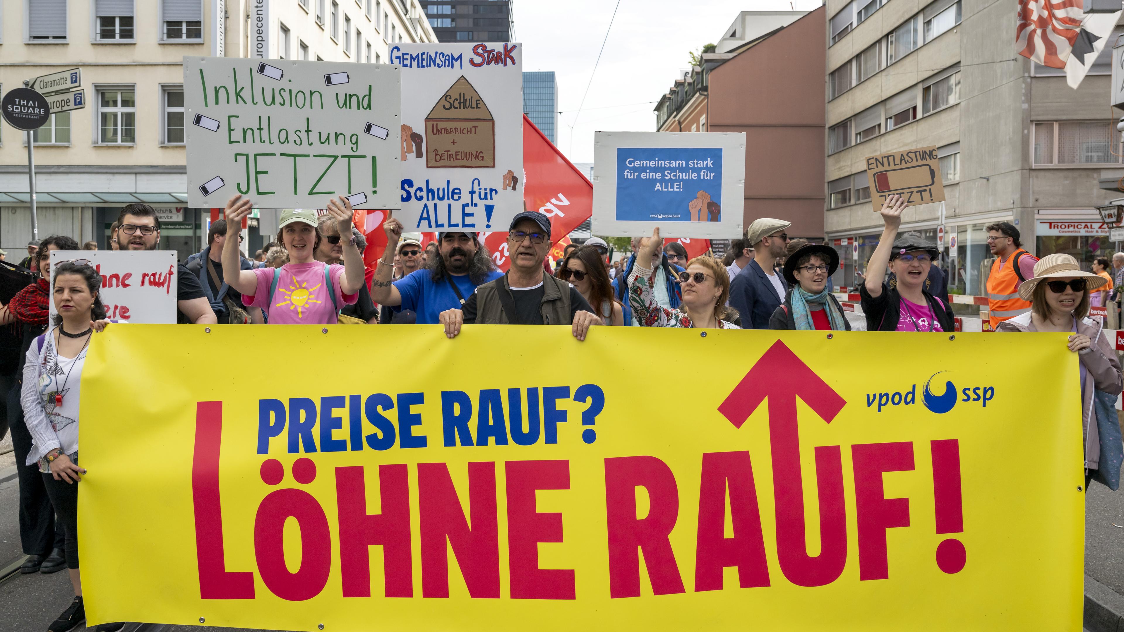 Schweiz, Basel: Demonstranten mit Transparenten protestieren an einer Kundgebung am Tag der Arbeit in Basel, am Mittwoch, 1. Mai 2024.