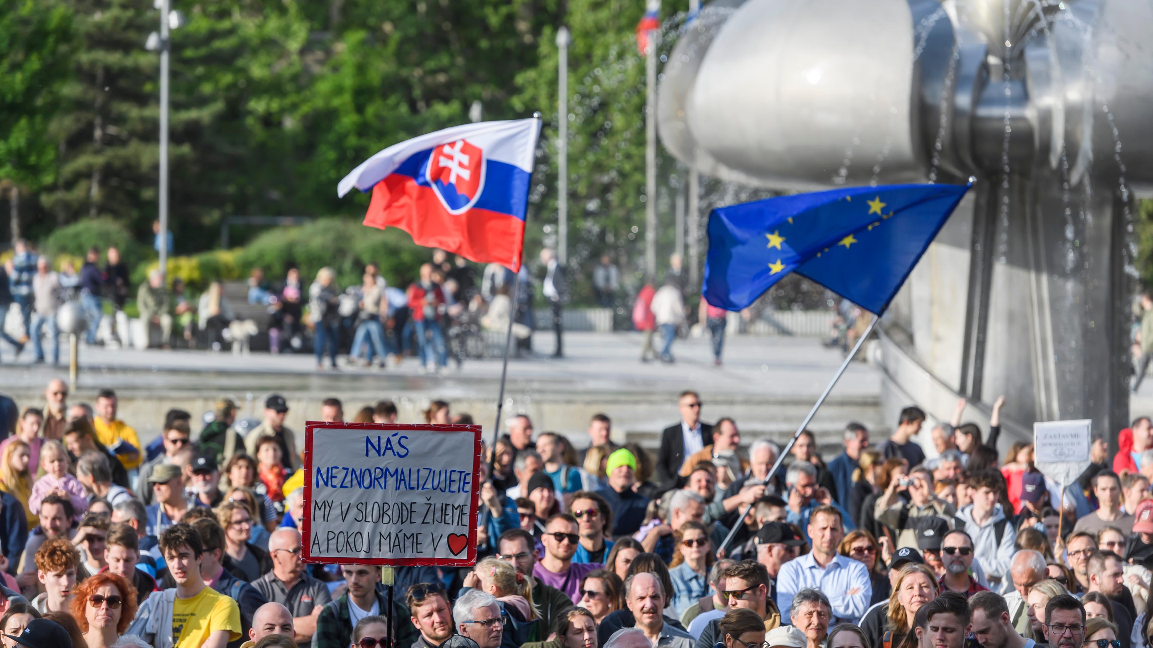 02.05.2024, Slowakei, Bratislava: Menschen demonstrieren auf den Straßen in der Slowakei für die Pressefreiheit. Man sieht Plakate und die Flagge Solwakeis. 