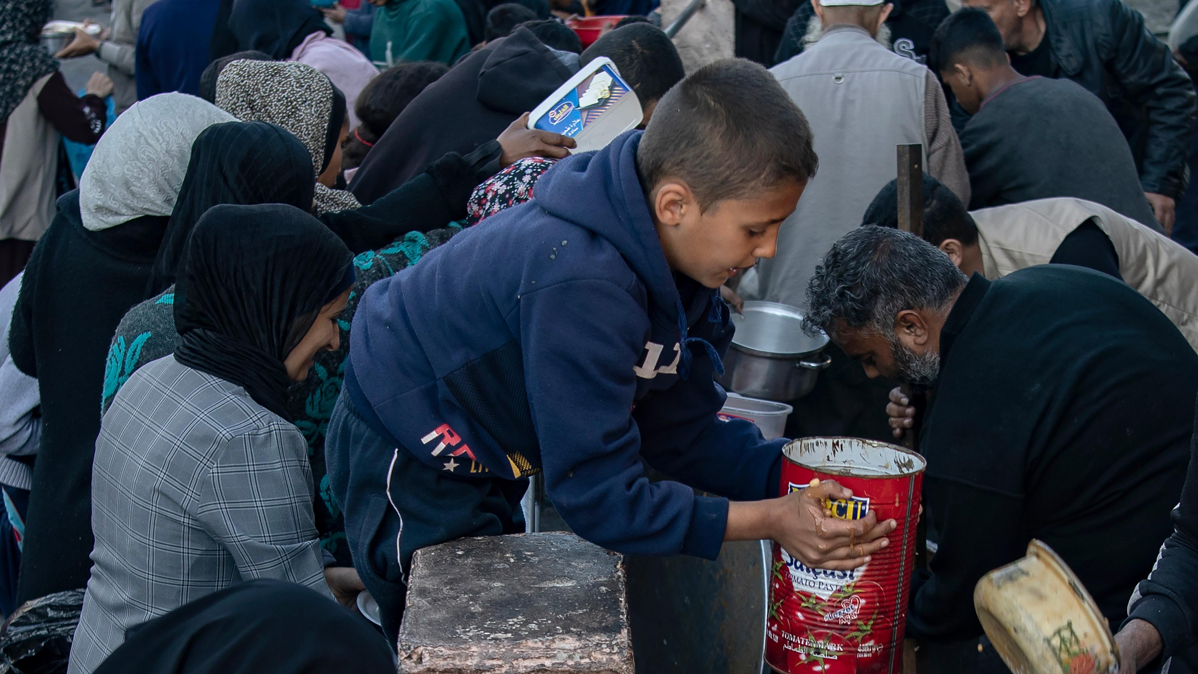 Internally displaced Palestinians in Rafah collect food before breaking fast during Ramadan