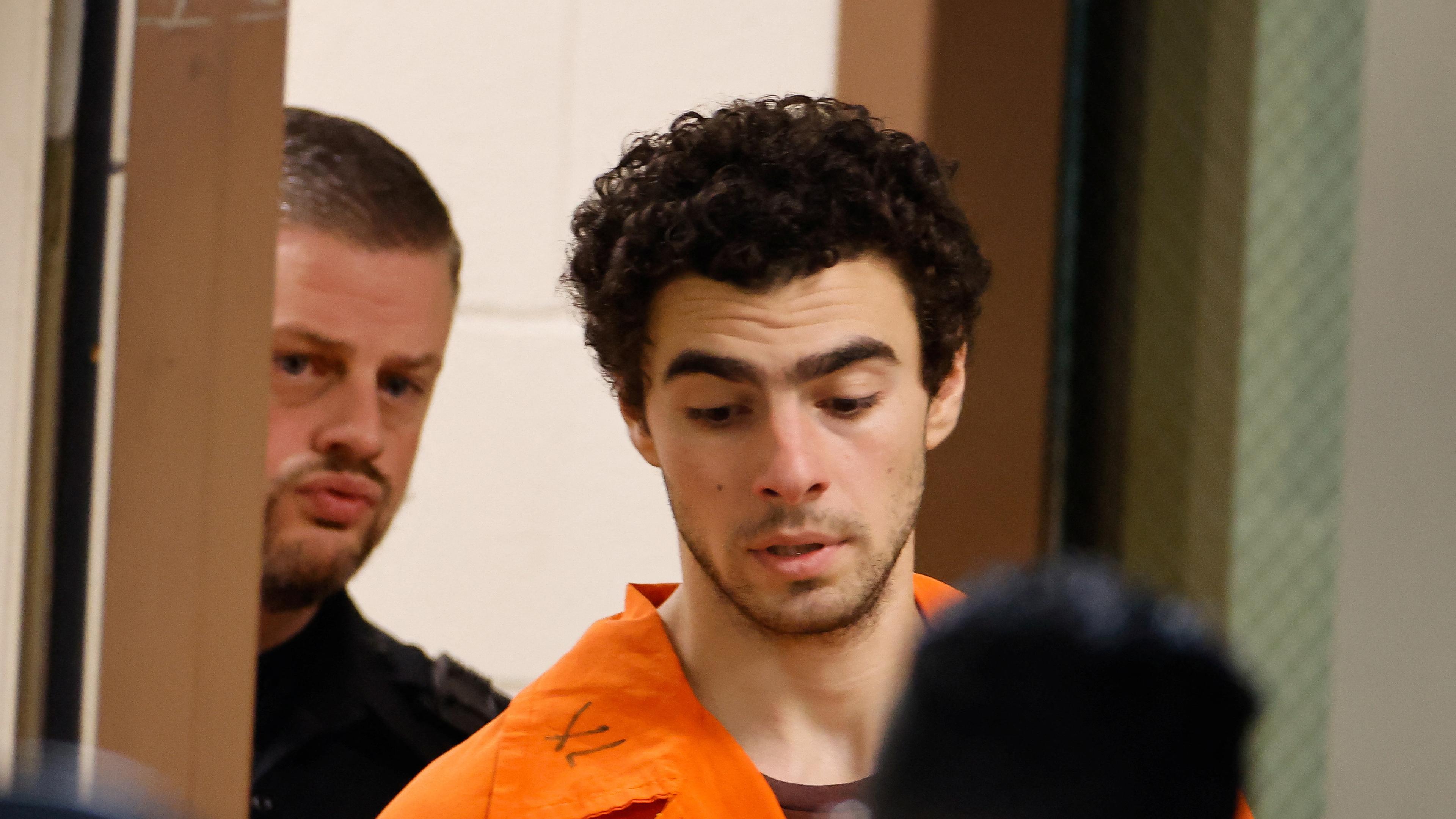Luigi Mangione, 26, a suspect in the New York City killing of UnitedHealth executive Brian Thompson, is escorted after an extradition hearing at Blair County Court House in Hollidaysburg, Pennsylvania