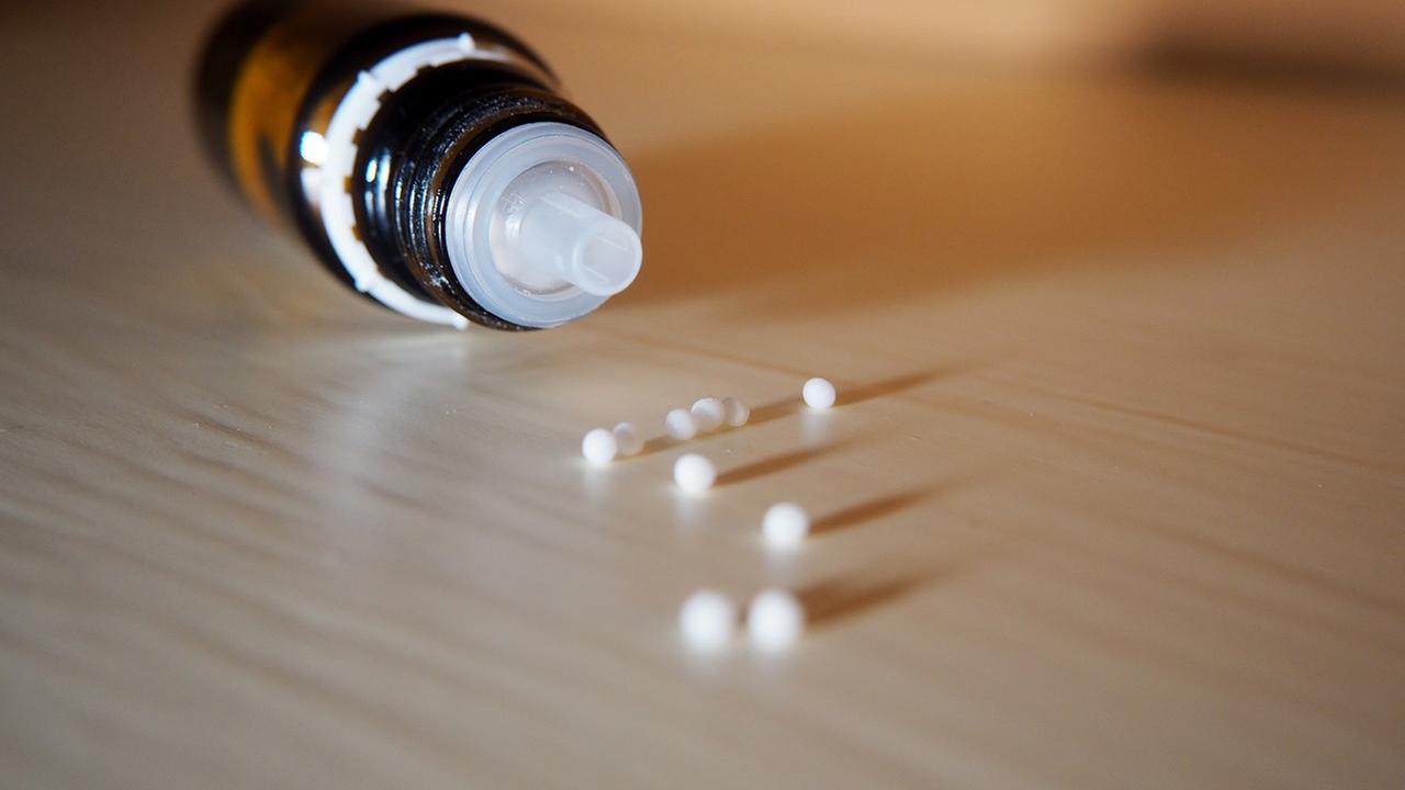 Homöopathie: Flasche und Kügelechen liegen auf einem Tisch