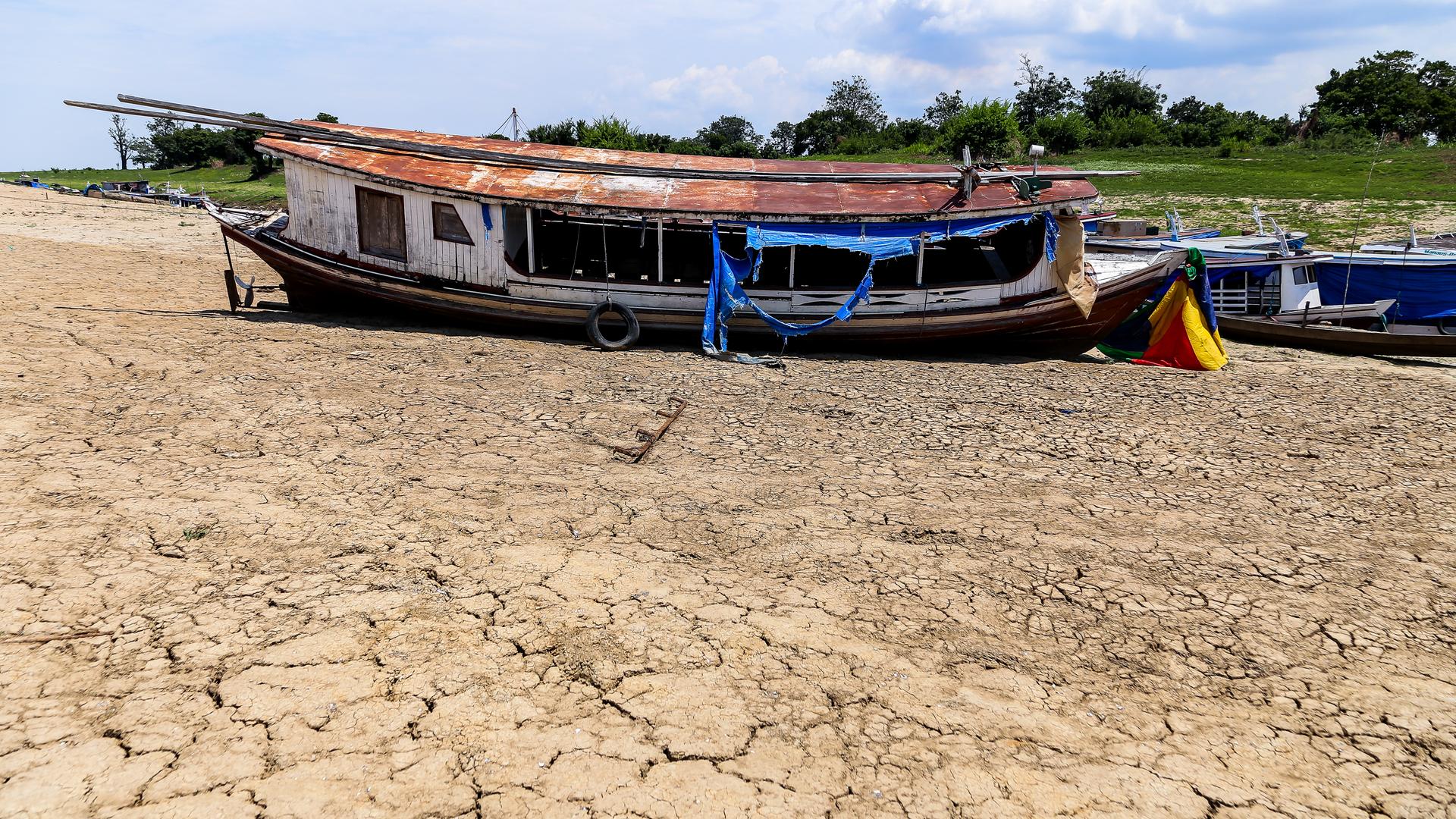 Dürre im Amazonas Regenwald. Kleines Boot im fast ausgetrockneten Fluss