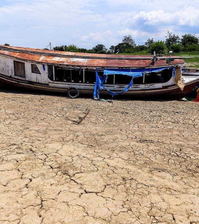 Dürre im Amazonas Regenwald. Kleines Boot im fast ausgetrockneten Fluss