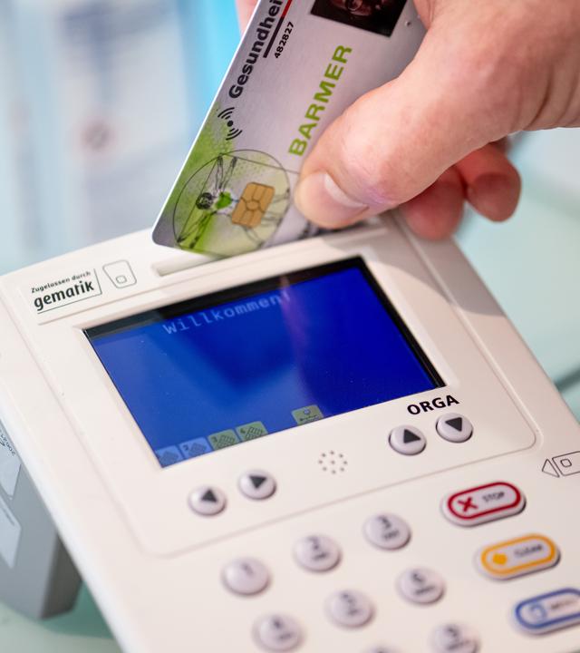 Krankenkarte wird in einen Kartenleser eingesteckt
